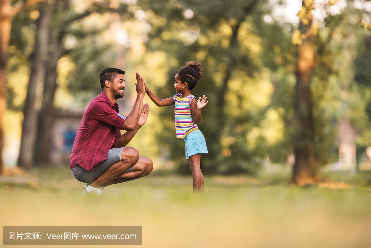 快乐的非洲裔美国父亲和女儿在户外玩拍手游戏
