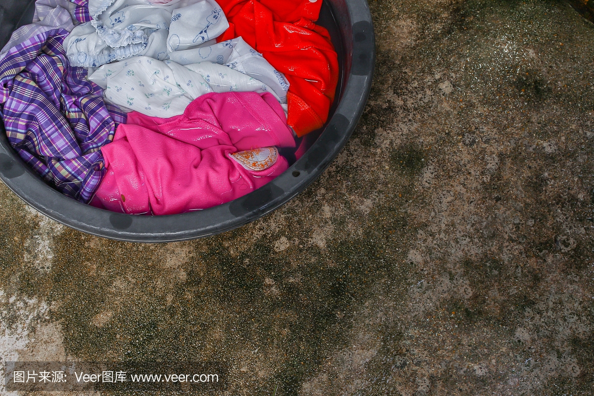 将肮脏的衣服浸在盆底黑色进行清洁