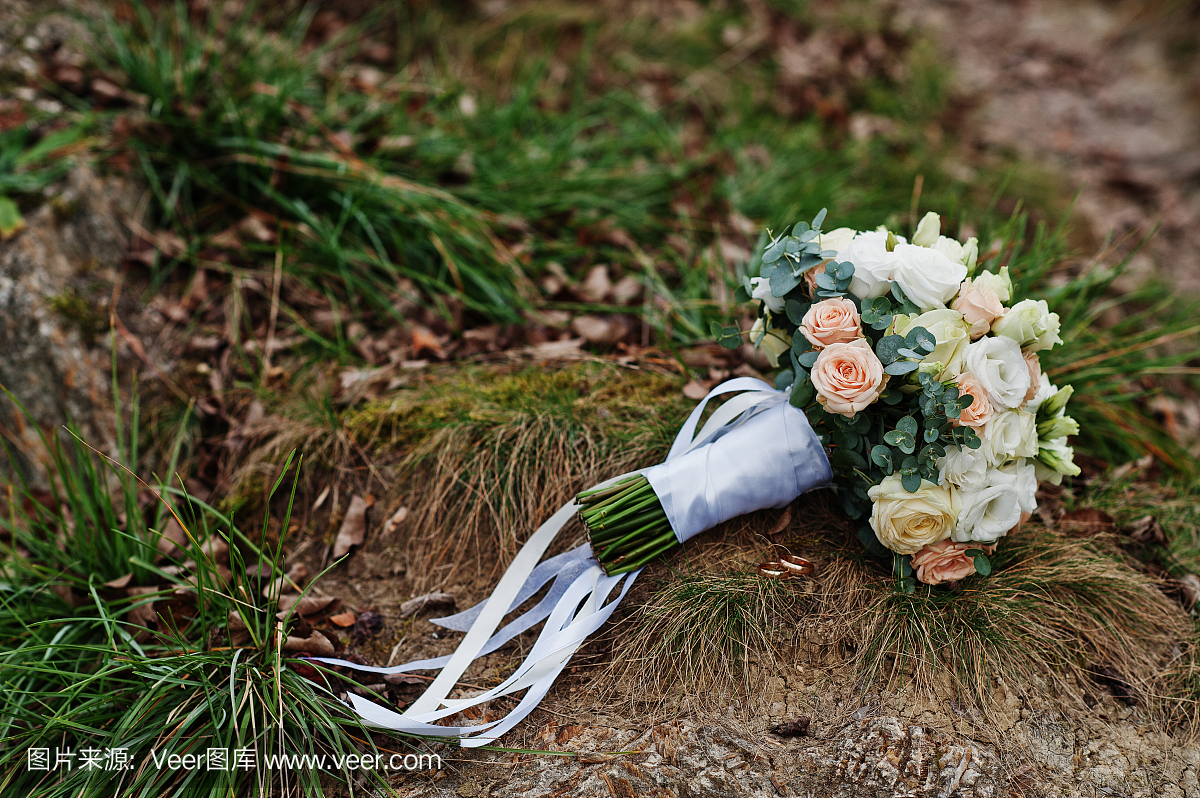 用白色丝带在草地上的婚礼花束。