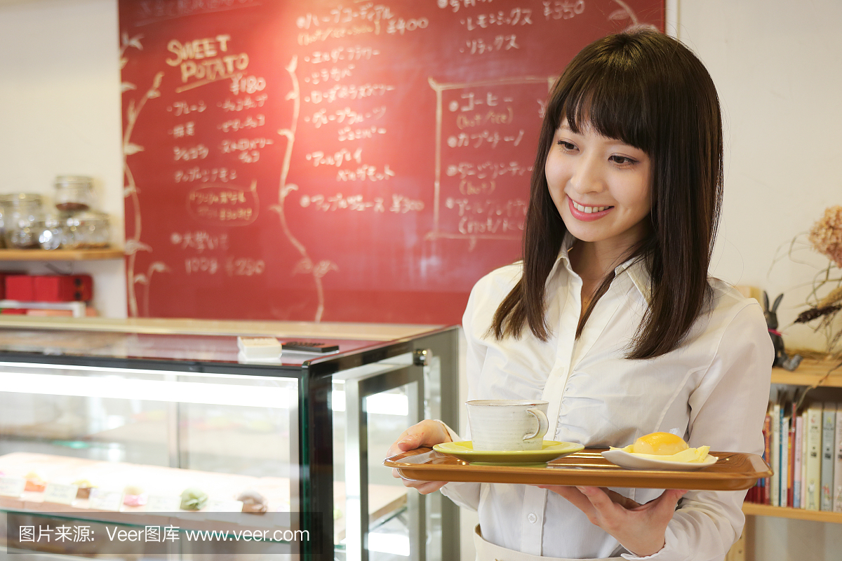 年轻漂亮女服务员在日本咖啡馆