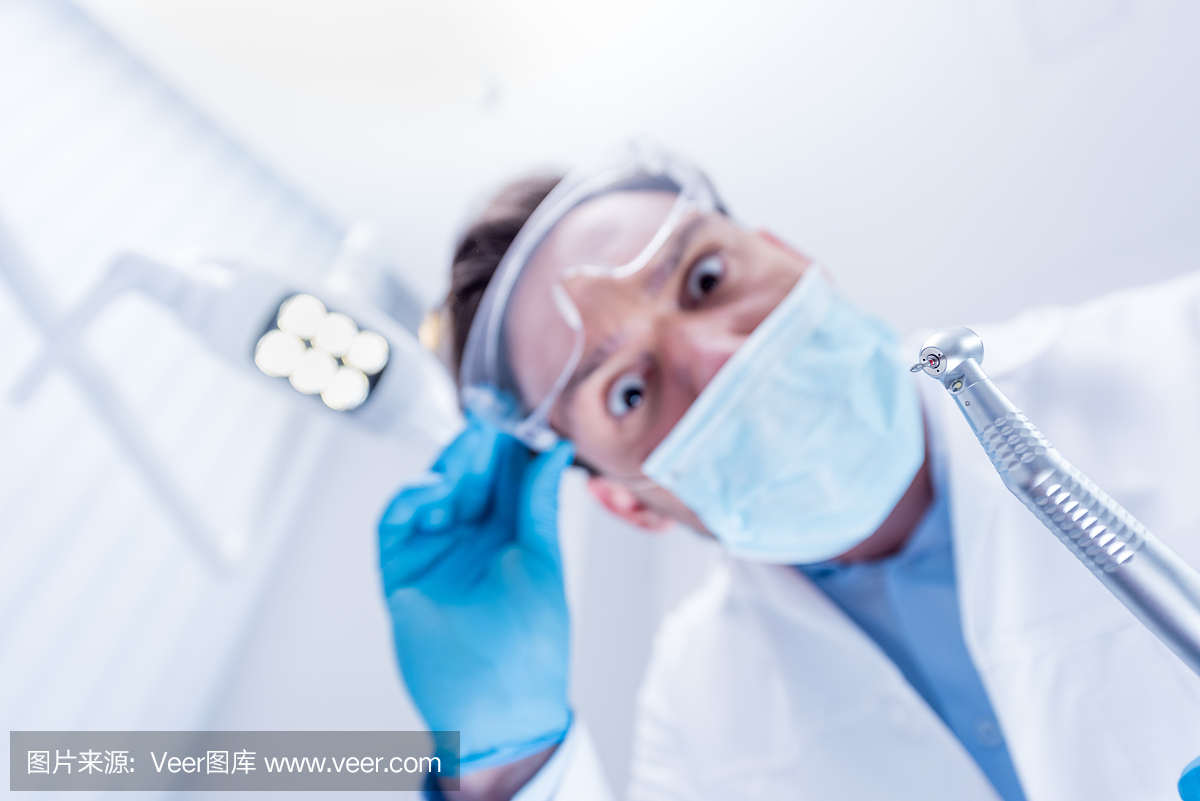 v面具面具和白色小荷持有牙医的视图的底外套风采牙钻十一点半图片
