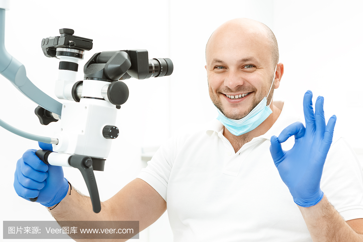 牙医在牙科显微镜附近做精细标志