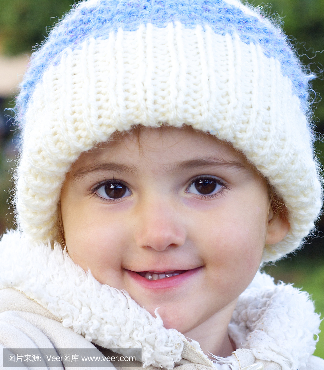 年轻的小孩,女孩,戴着一条羊毛帽子微笑