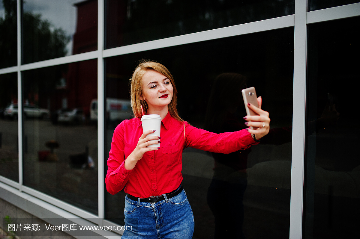 一个美丽的女人,穿着红色上衣和休闲牛仔裤采