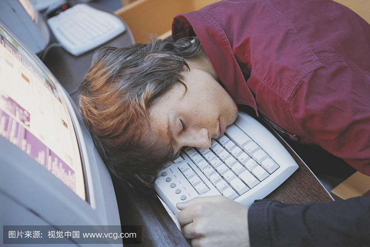 大学生在电脑键盘上睡着了