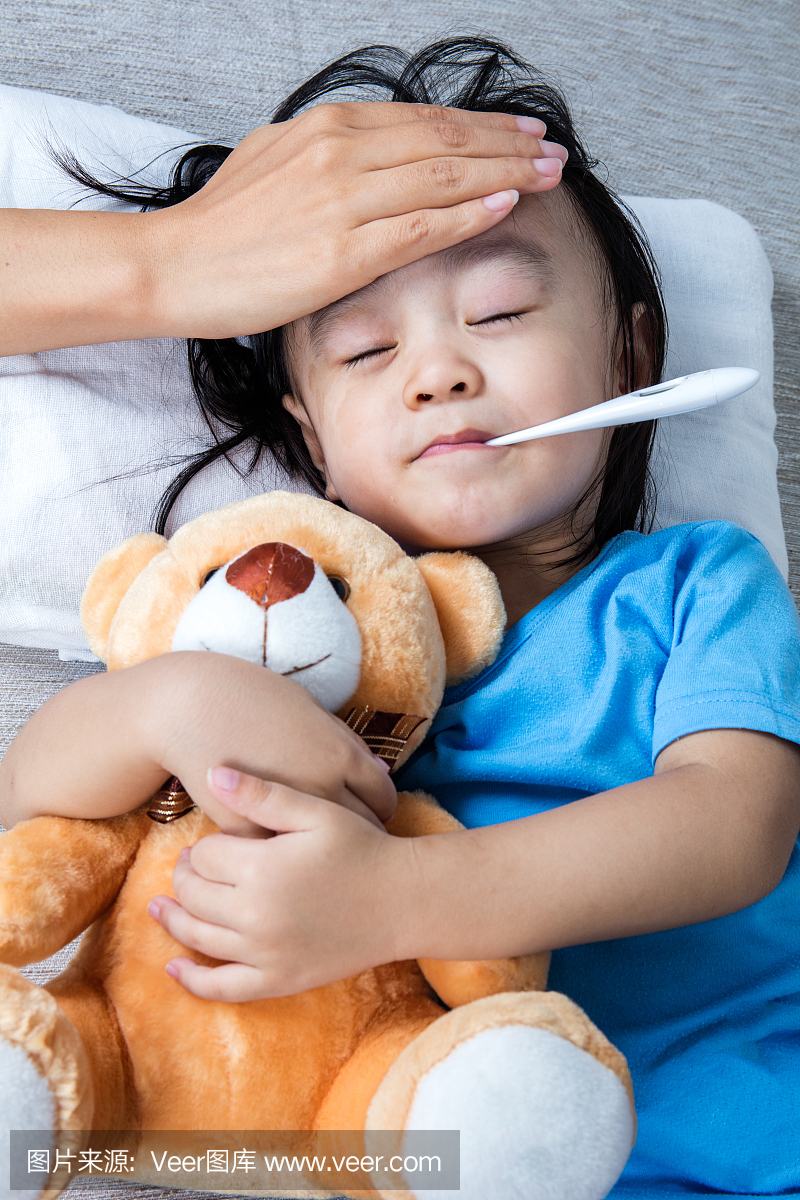 亚洲中国母亲测量小女孩额头发烧