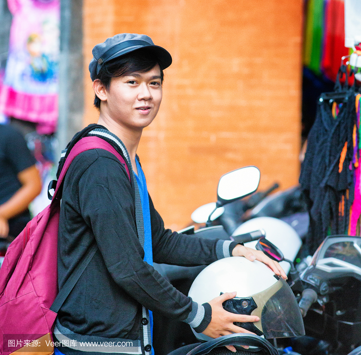 年轻的印尼男子在市场上停放自行车