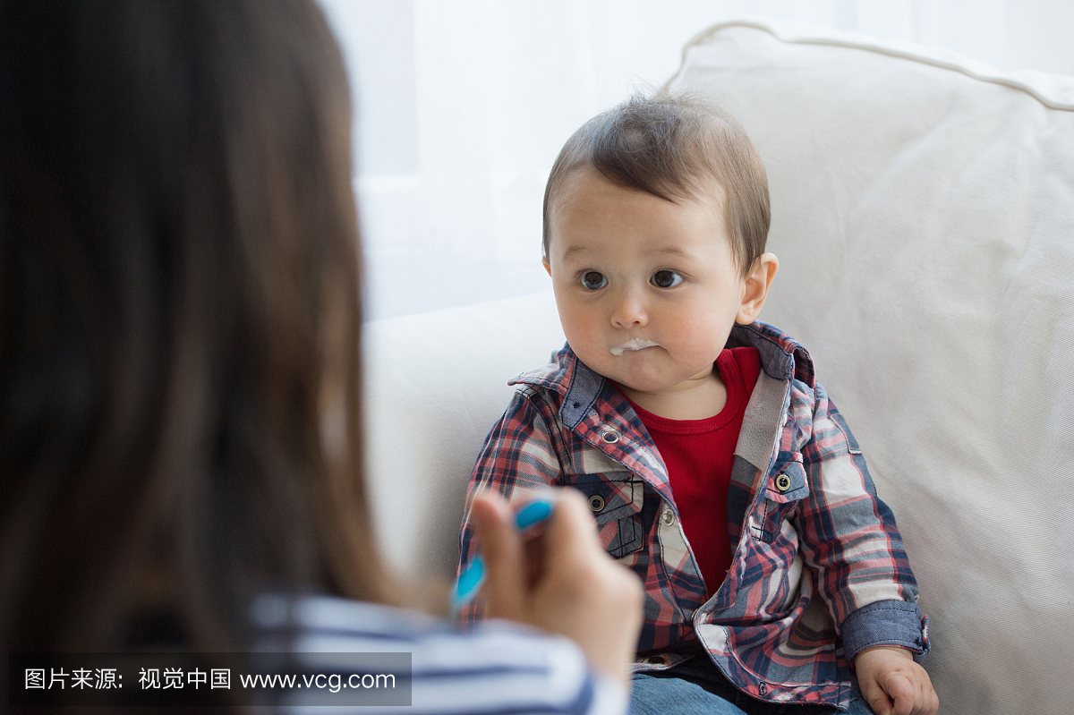 母亲用勺子喂婴儿