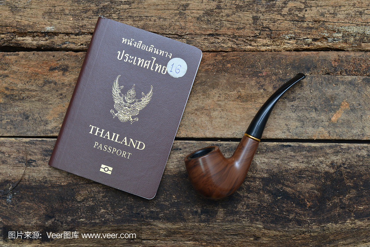 泰国护照和木制背景上的烟草管