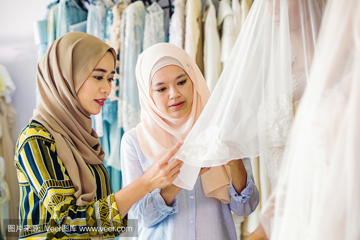 讨论在婚纱店的面料的穆斯林妇女