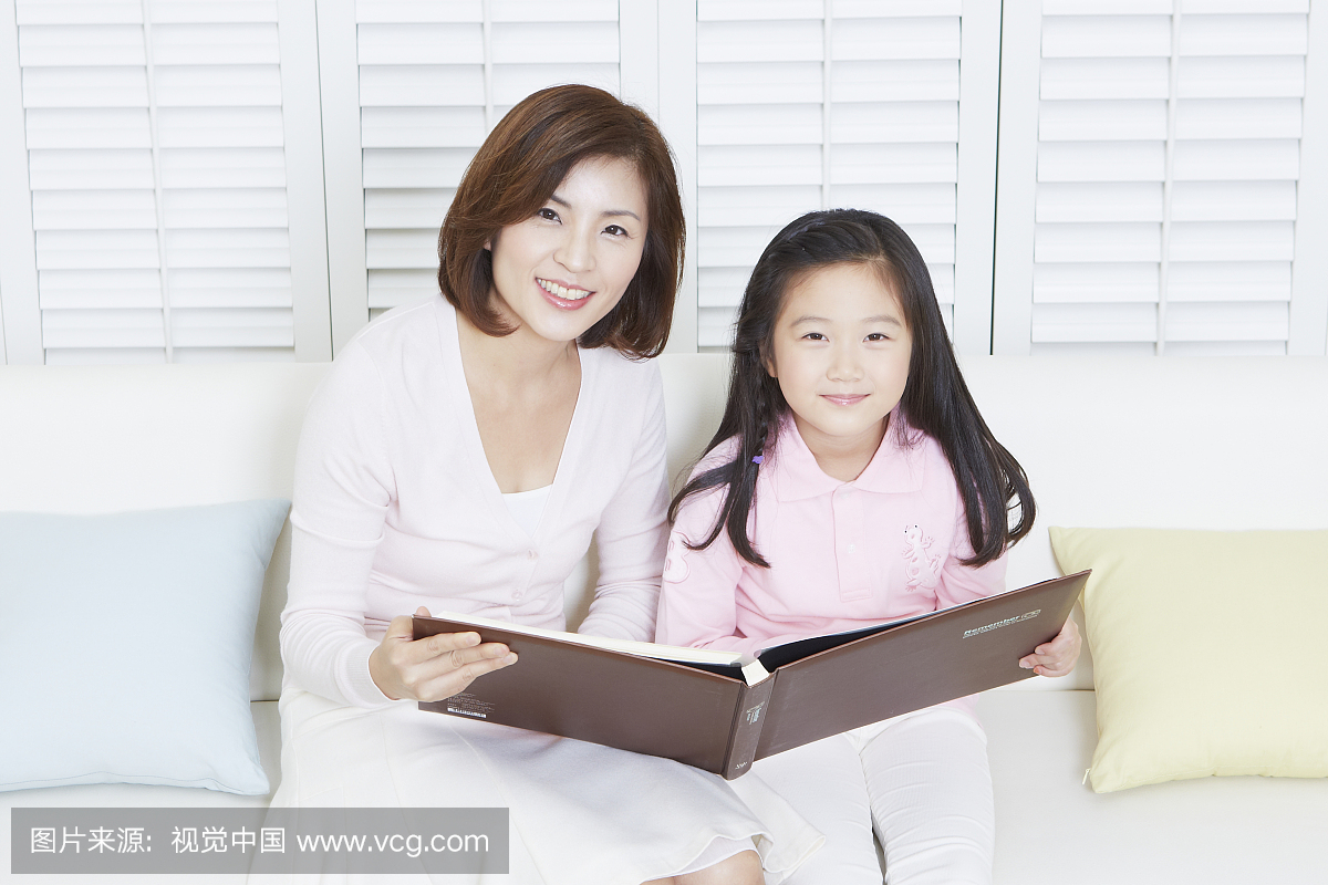 Woman and her daughter reviewing album toge