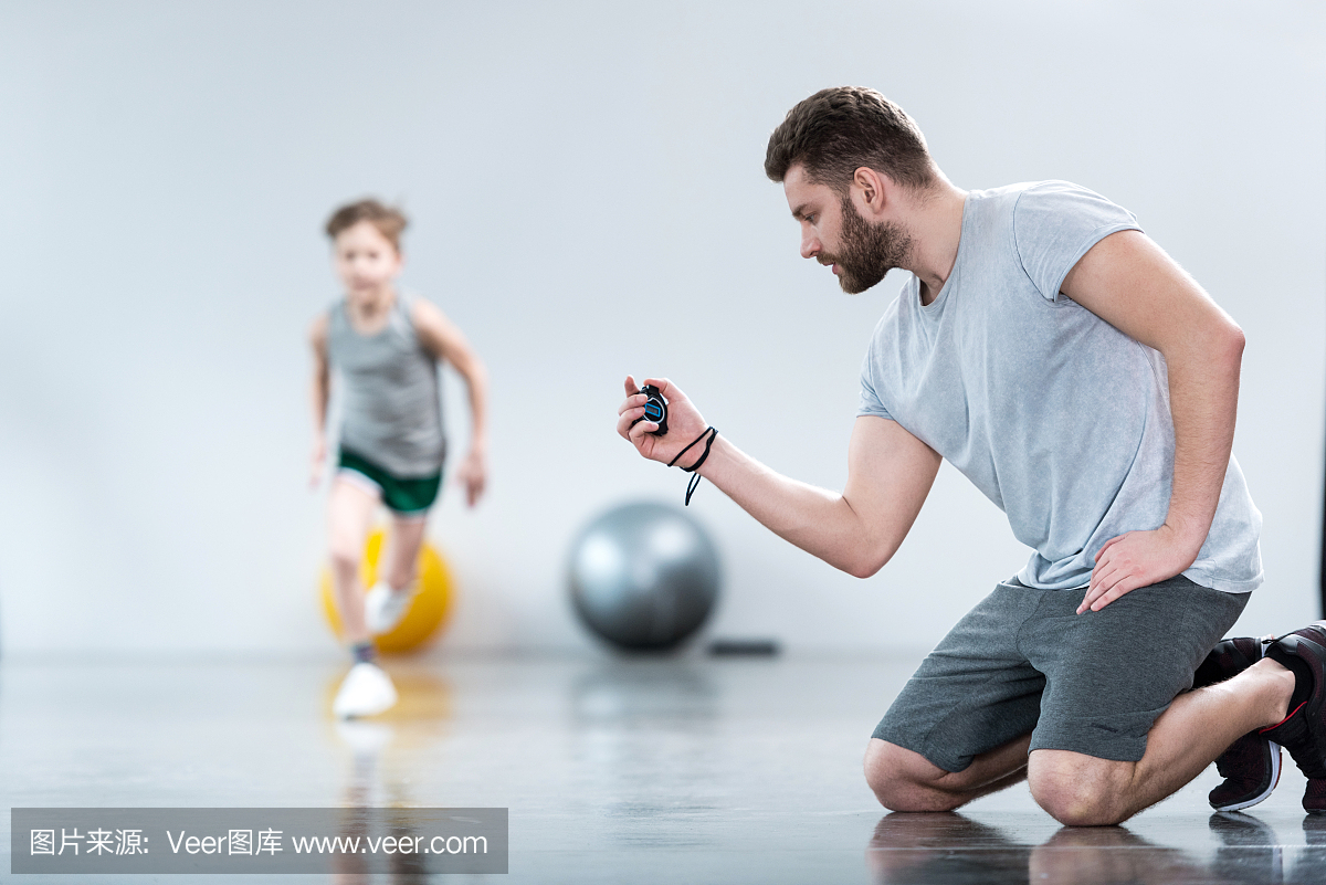 男孩与健身中心的教练一起锻炼身体