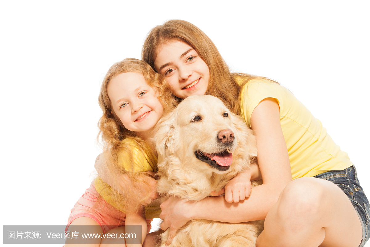 两个金发女孩拥抱他们的金毛猎犬
