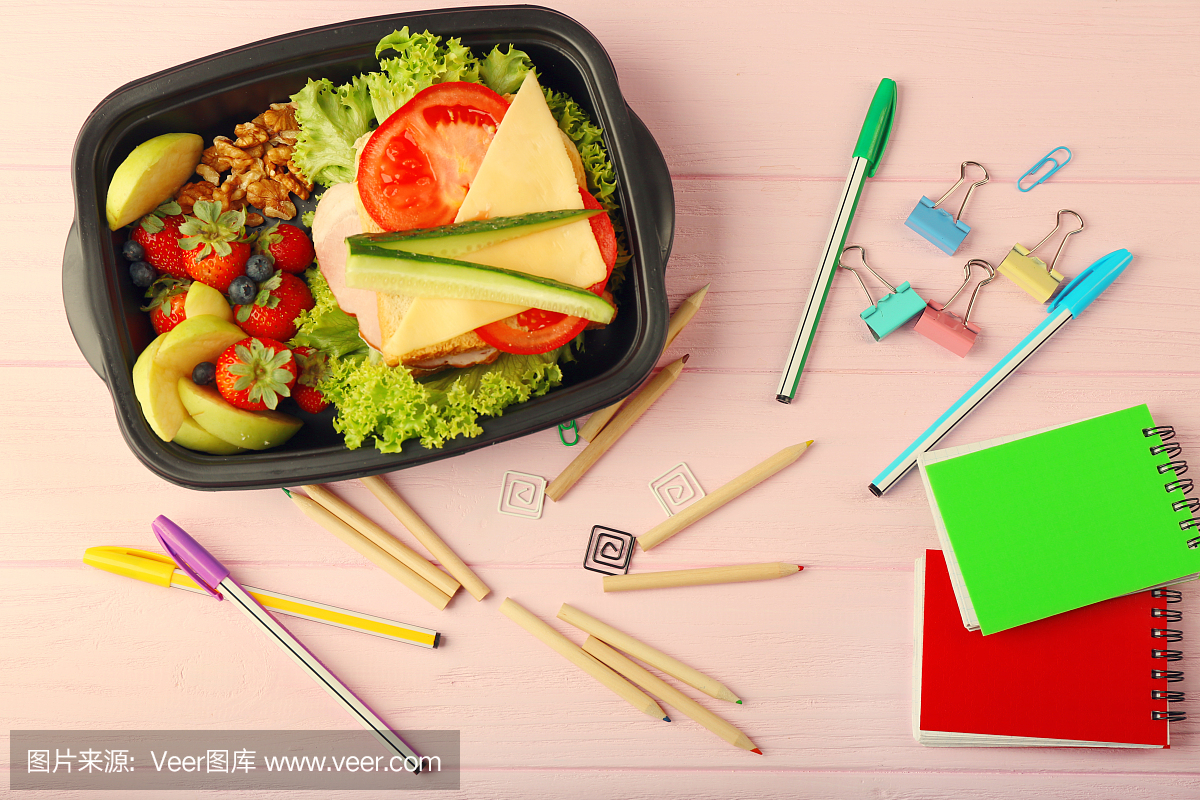 Lunchbox with dinner and stationery on pink wo