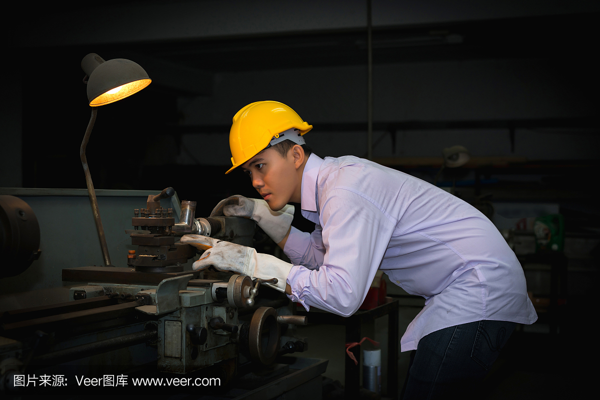 亚洲工程师男人戴着安全帽检查和使用设备在实