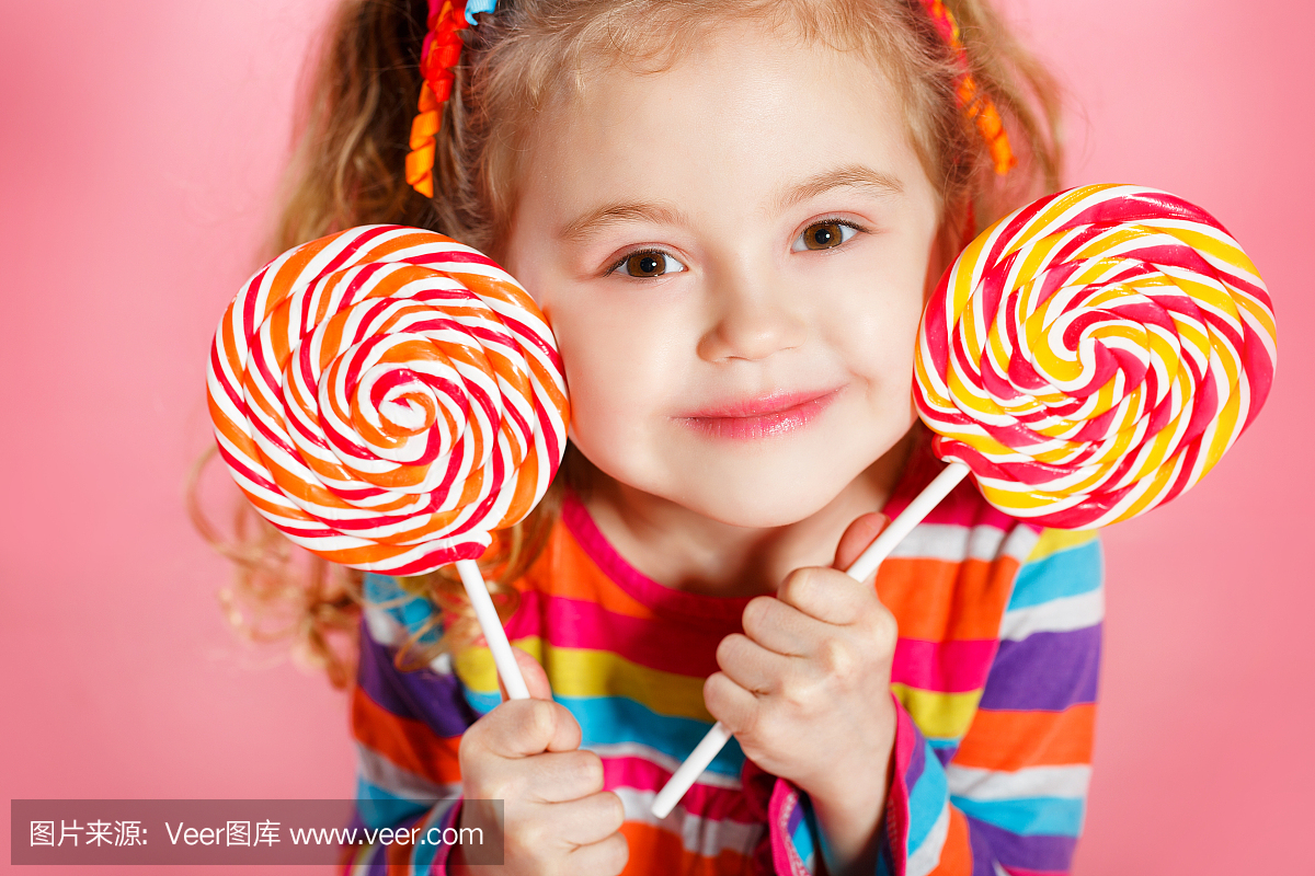 一个快乐的小女孩与棒棒糖的工作室肖像