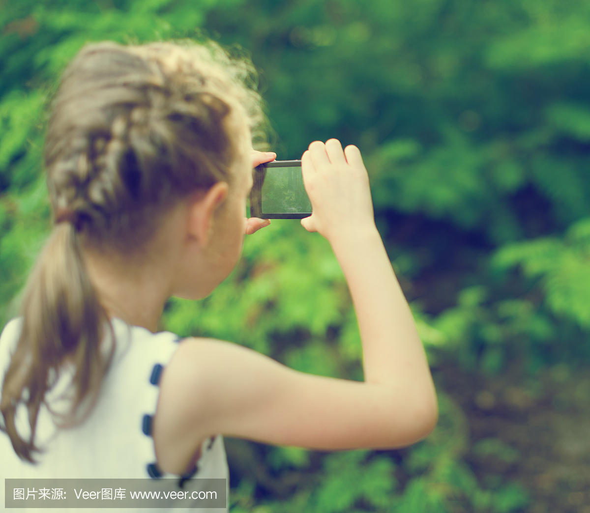 用手机制作视频或照片的小女孩。