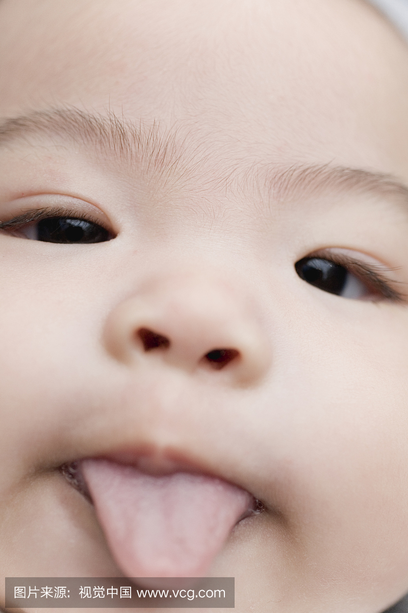 女婴(0-3个月)伸出舌头,特写镜头