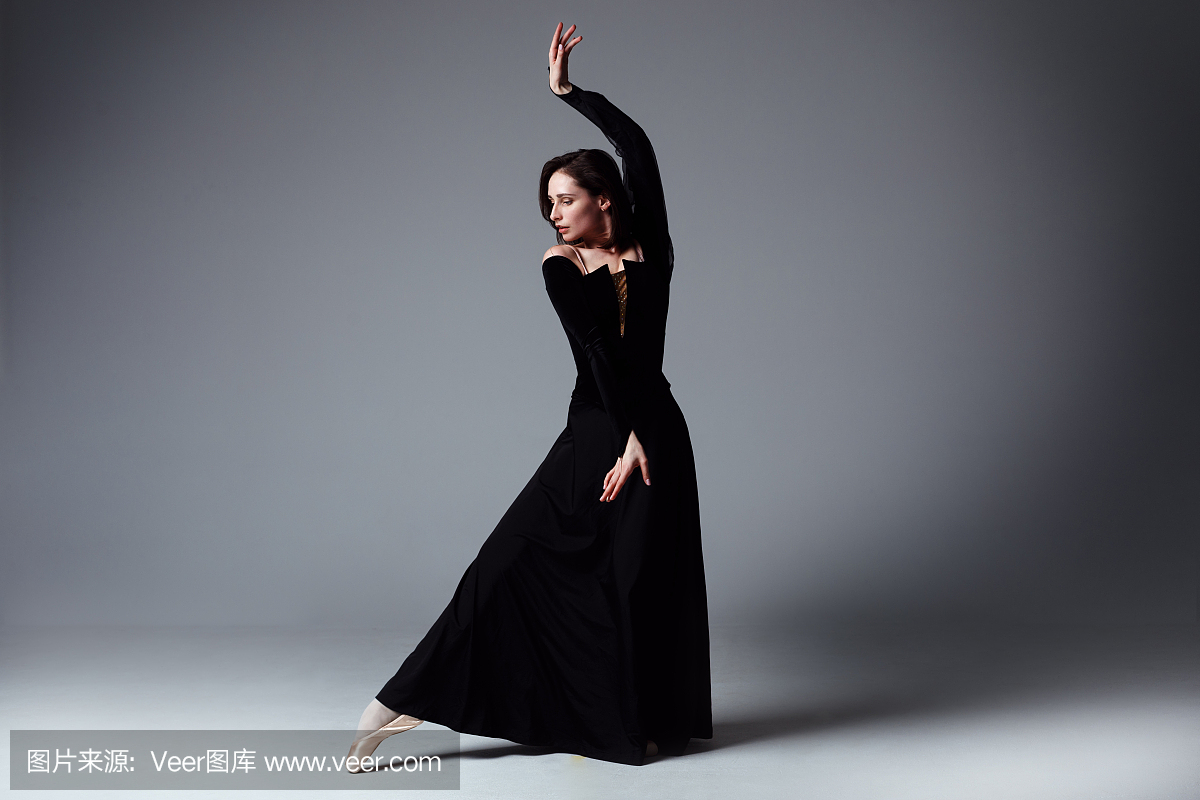 黑色长裙的苗条芭蕾舞演员在photostudio中呈