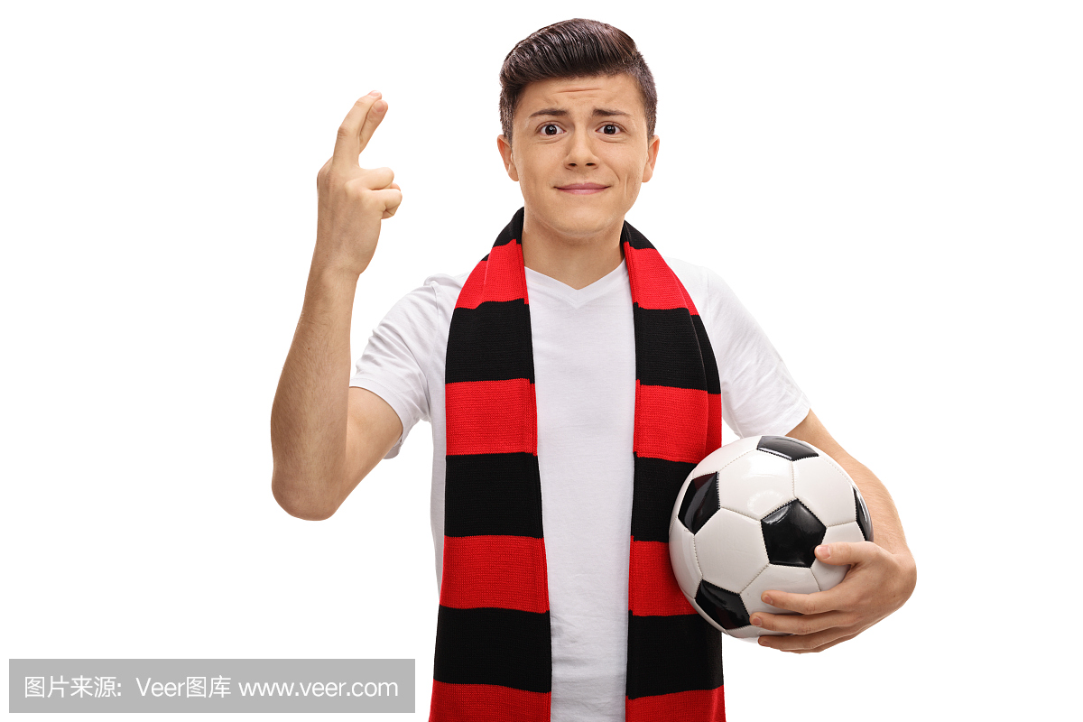 少年足球迷用围巾和橄榄球举着他的手指交叉
