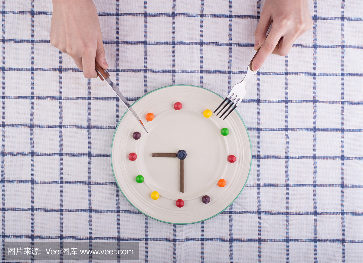 午餐时间概念,时钟在盘子,刀叉
