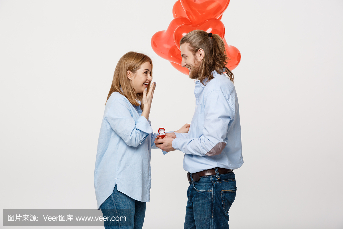 年轻帅哥的肖像给一个女孩带着红色的心形气球