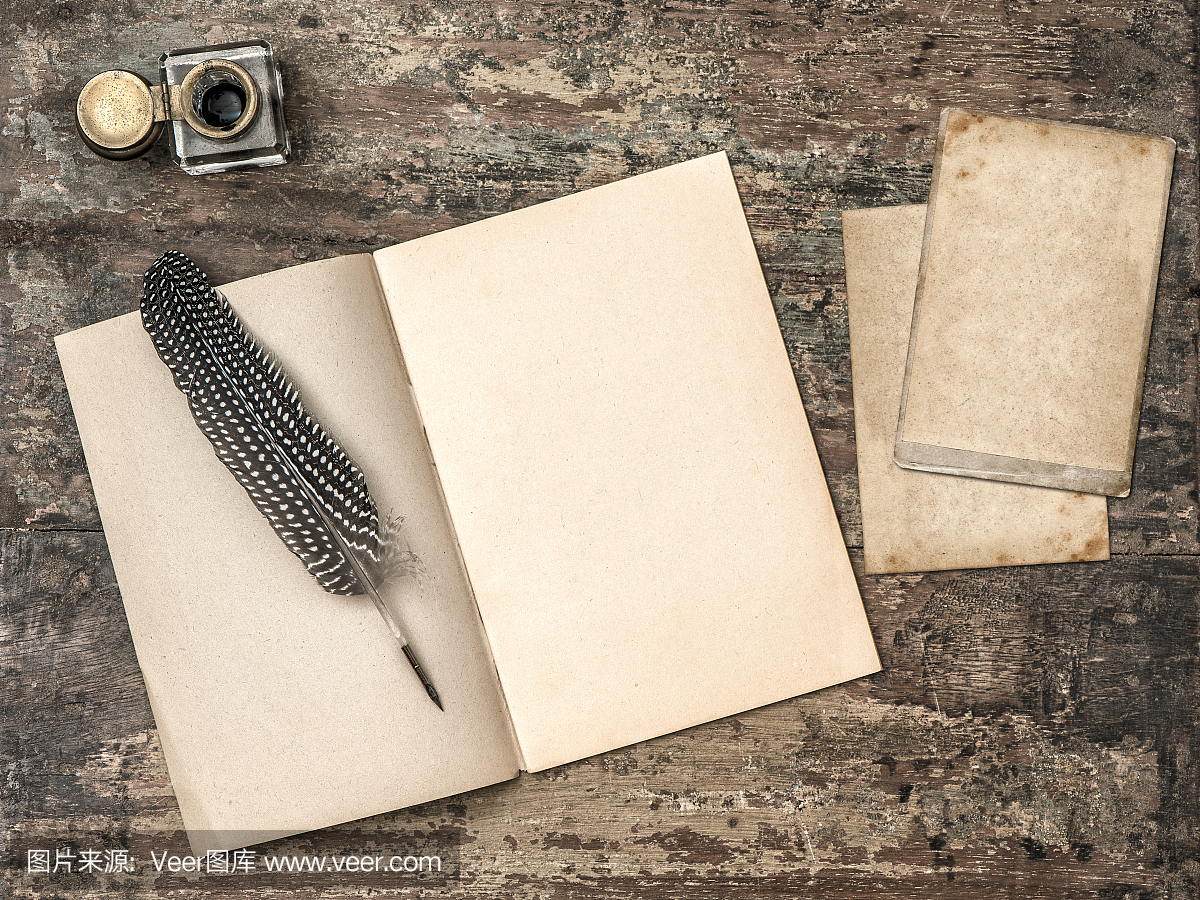 打开书,复古写作工具羽毛笔和墨迹