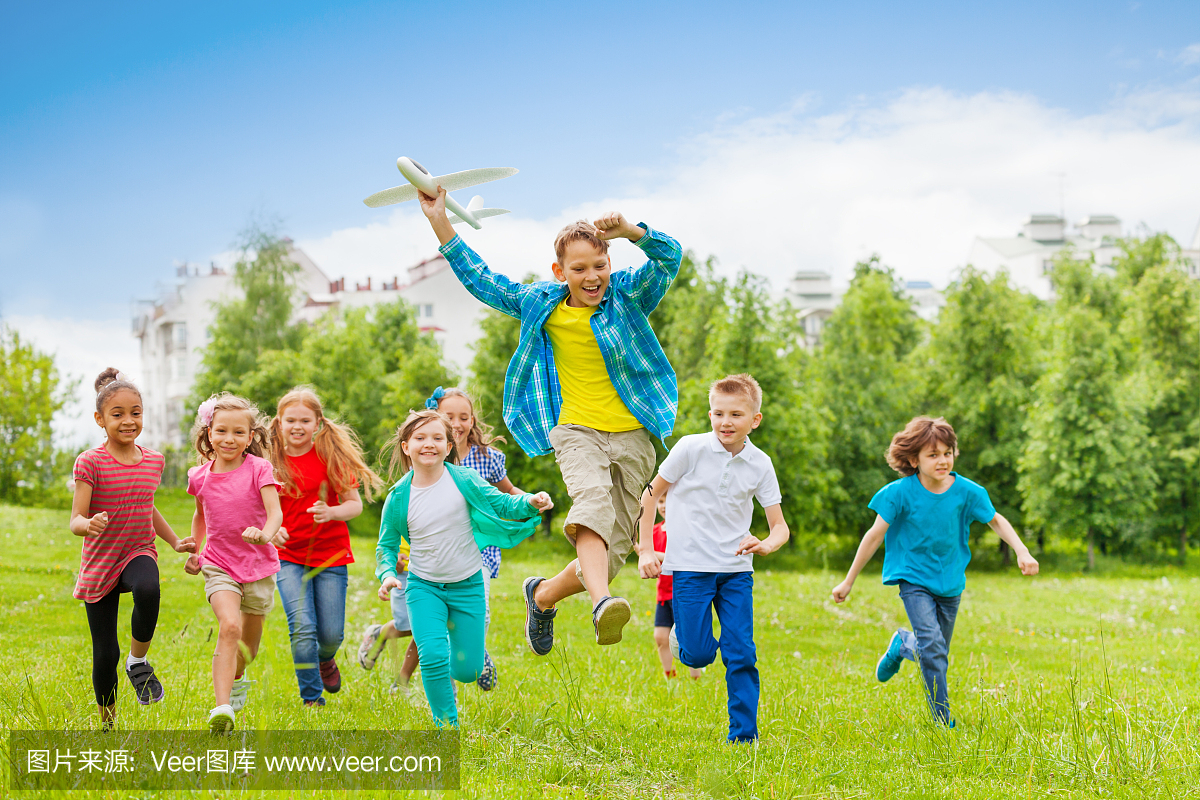 跳跃的男孩抱着大飞机玩具和孩子