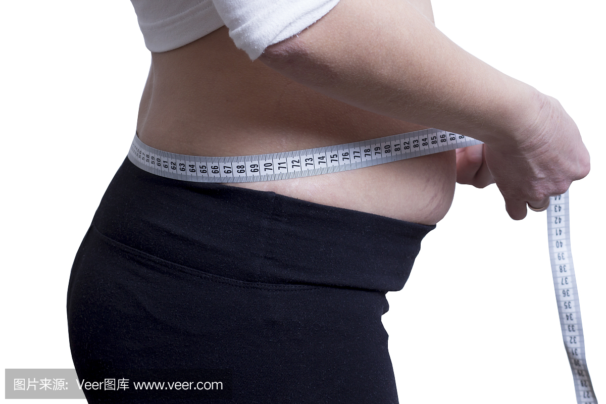 胖女孩测量腰部的大小。减肥的概念。观看图。