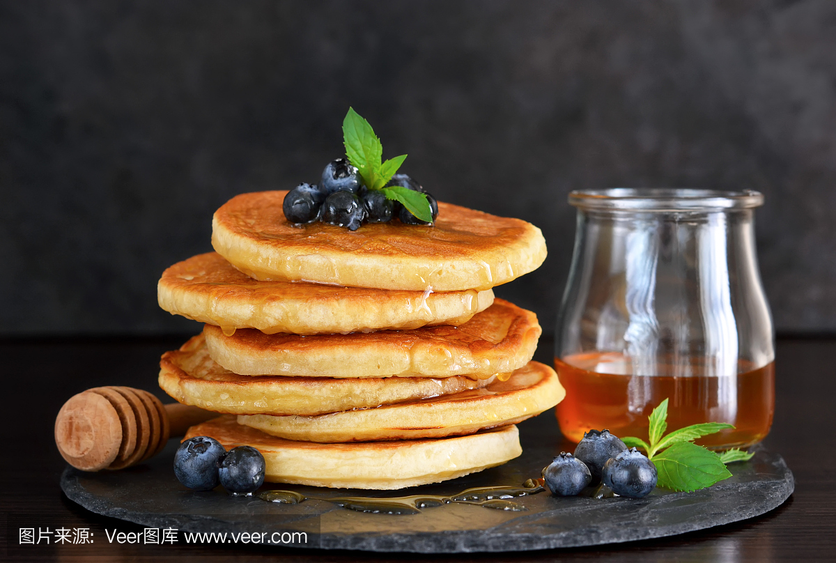 蜂蜜和蓝莓自制燕麦煎饼在石板上吃早饭。早上