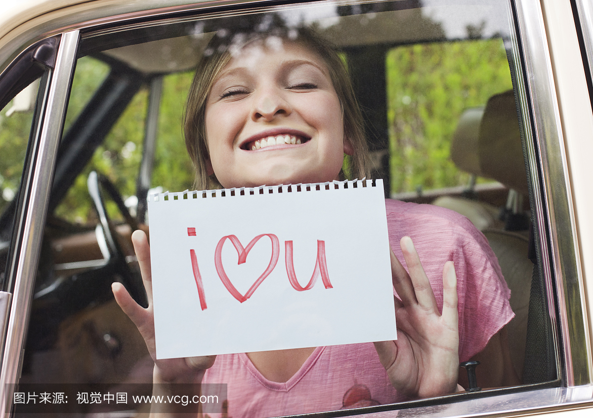 车里的女人拿着标志说我爱你