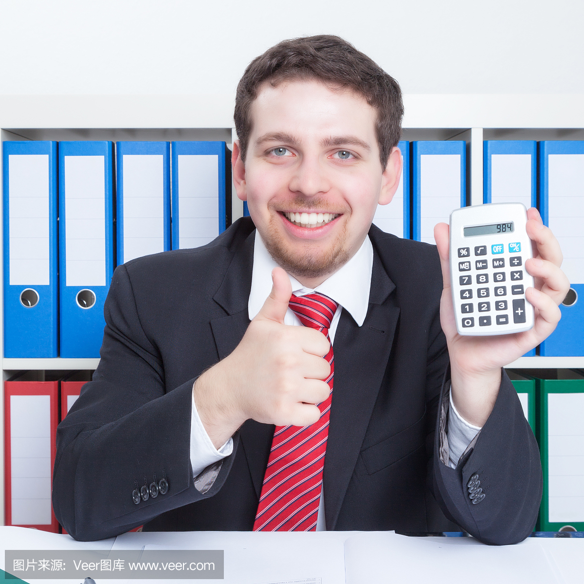 智能商人在黑色西装在办公室与计算器