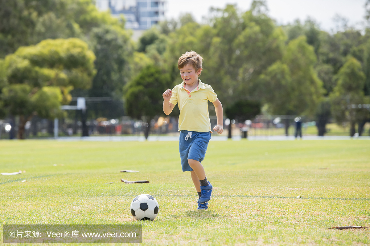 年轻的小孩子7或8岁享受快乐的踢足球足球在