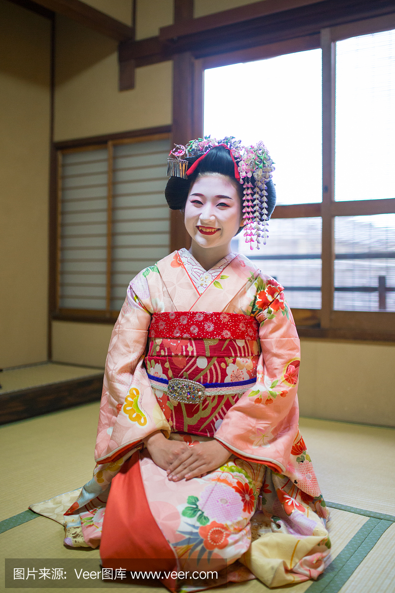 Maiko女孩坐在高跟鞋在日本榻榻米房间