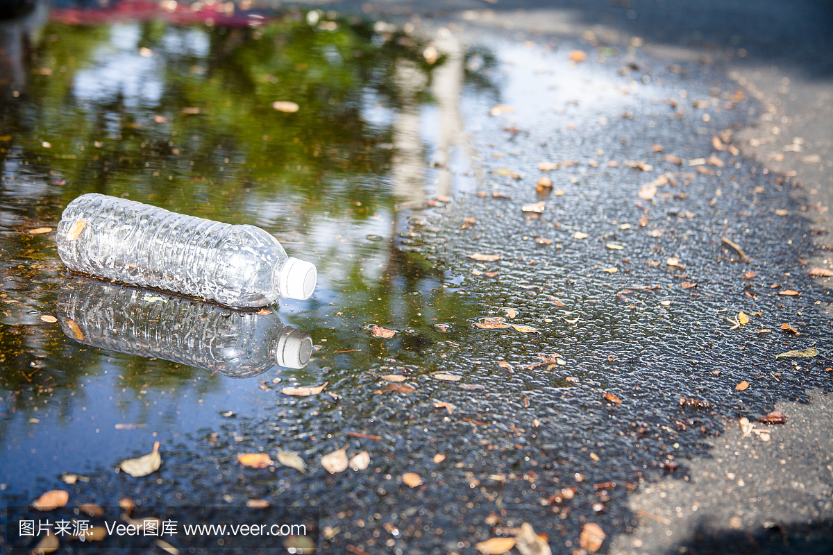 污染。在城市街道上丢弃空的塑料水瓶。