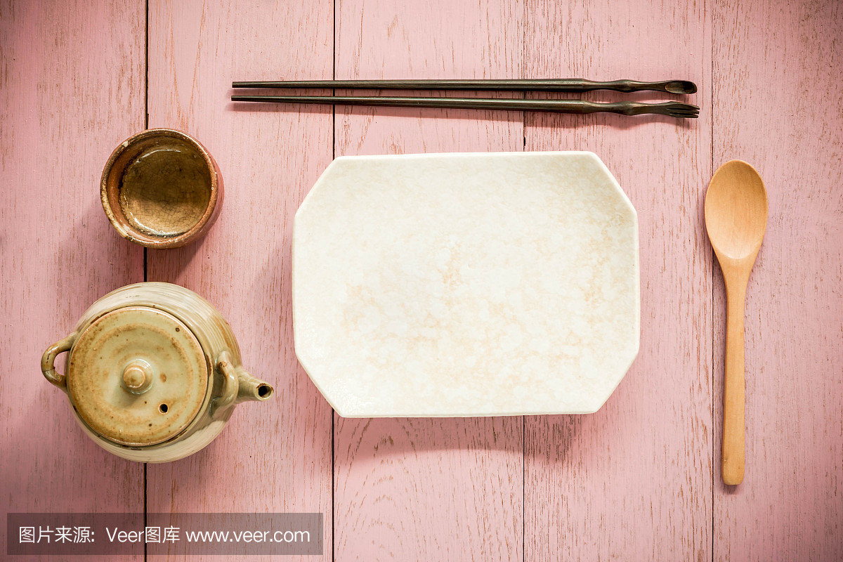 用亚洲茶壶和茶杯放筷子和盘子。